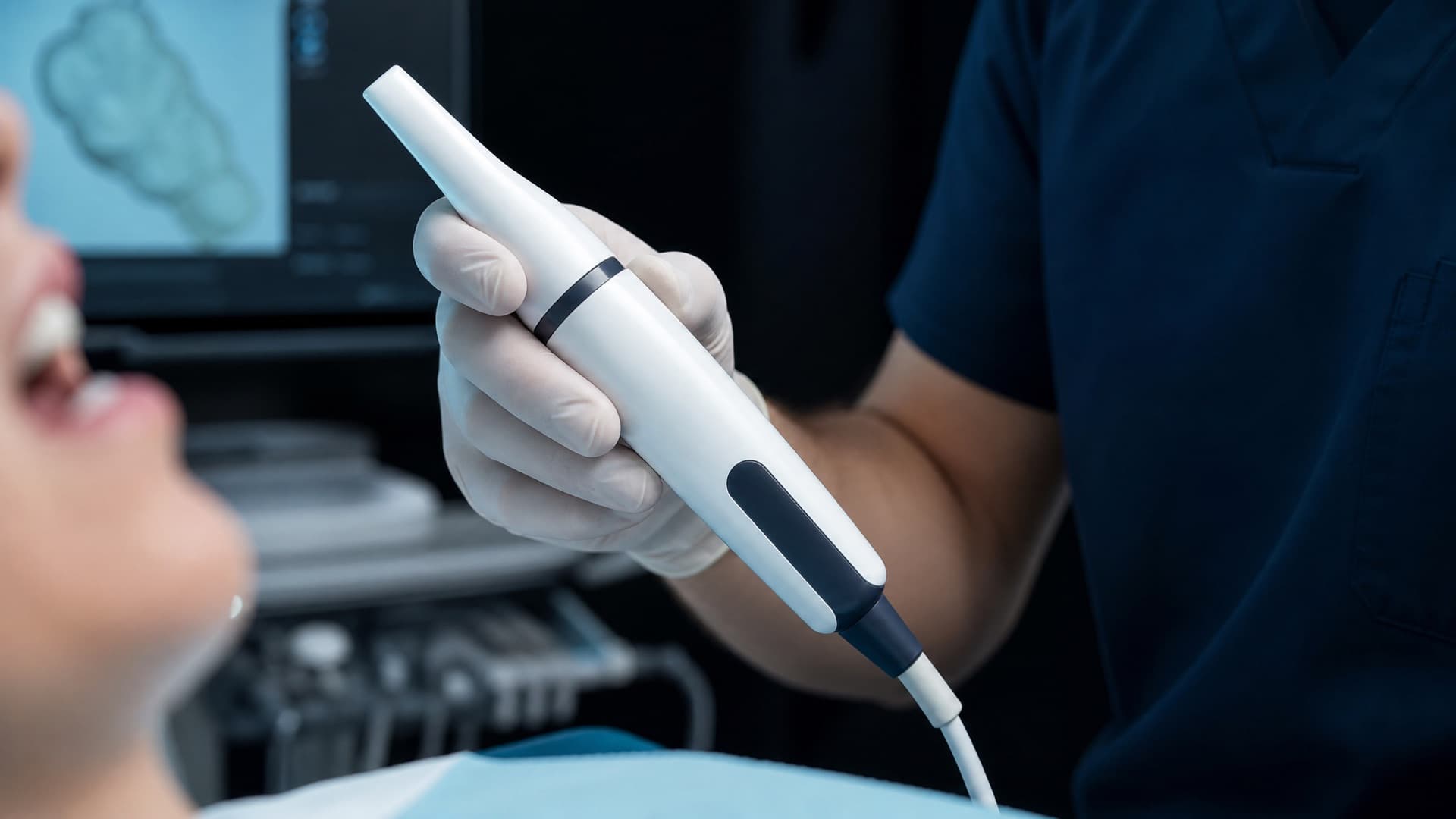 Behandler führt einen Intraoralscanner ohne Beschriftung am Behandlungsstuhl